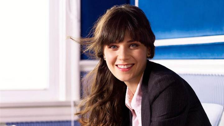 Smiling Zooey Deschanel In Black Coat Looking At Camera